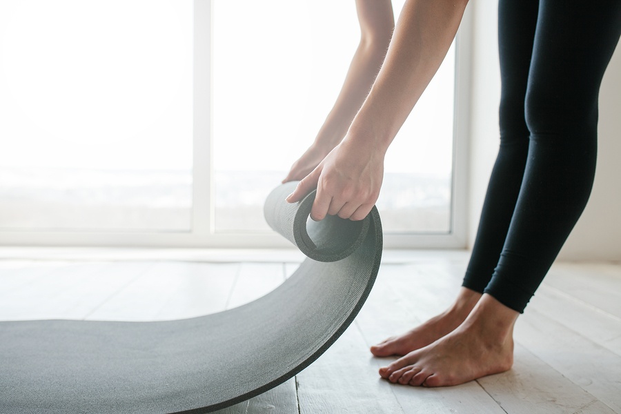 Woman rolling up a yoga mat