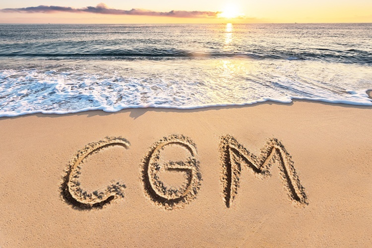 Photo of a beach with "CGM" written in the sand