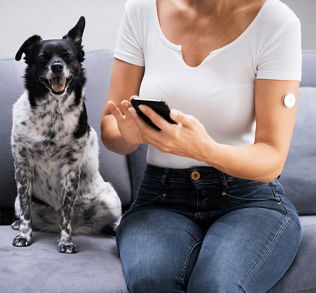 A woman testing glucose levels on a smart phone