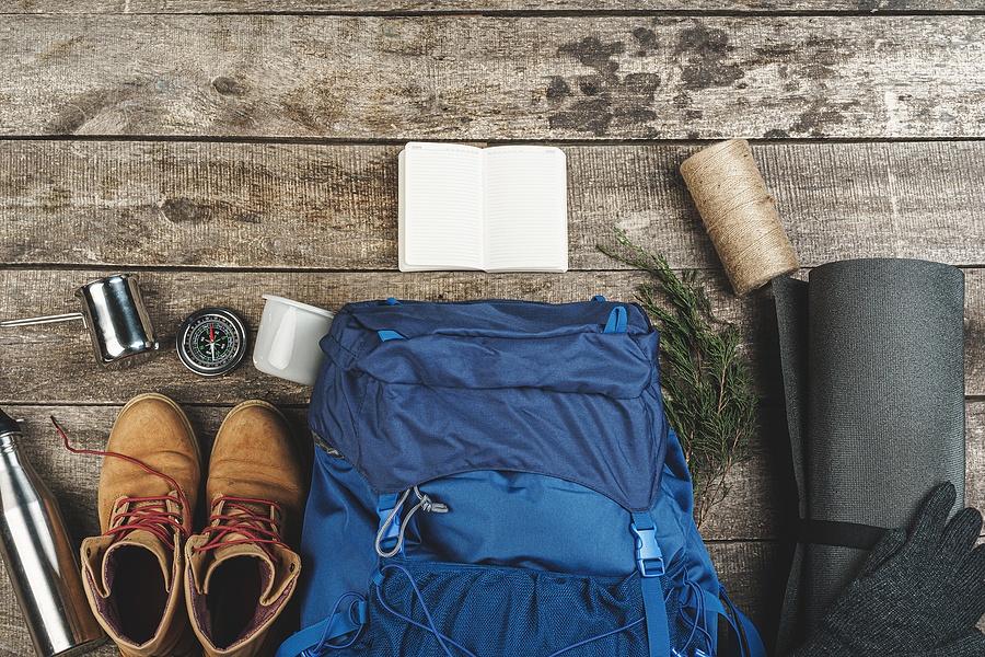 Backpack And Hiking Equipment On Wooden Background, Top View Backpack And Hiking Equipment On Wooden Background, Top View