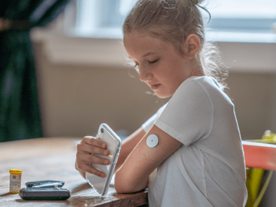 child embracing diabetes technology