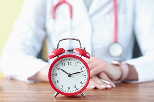 Red clock with doctor behind it