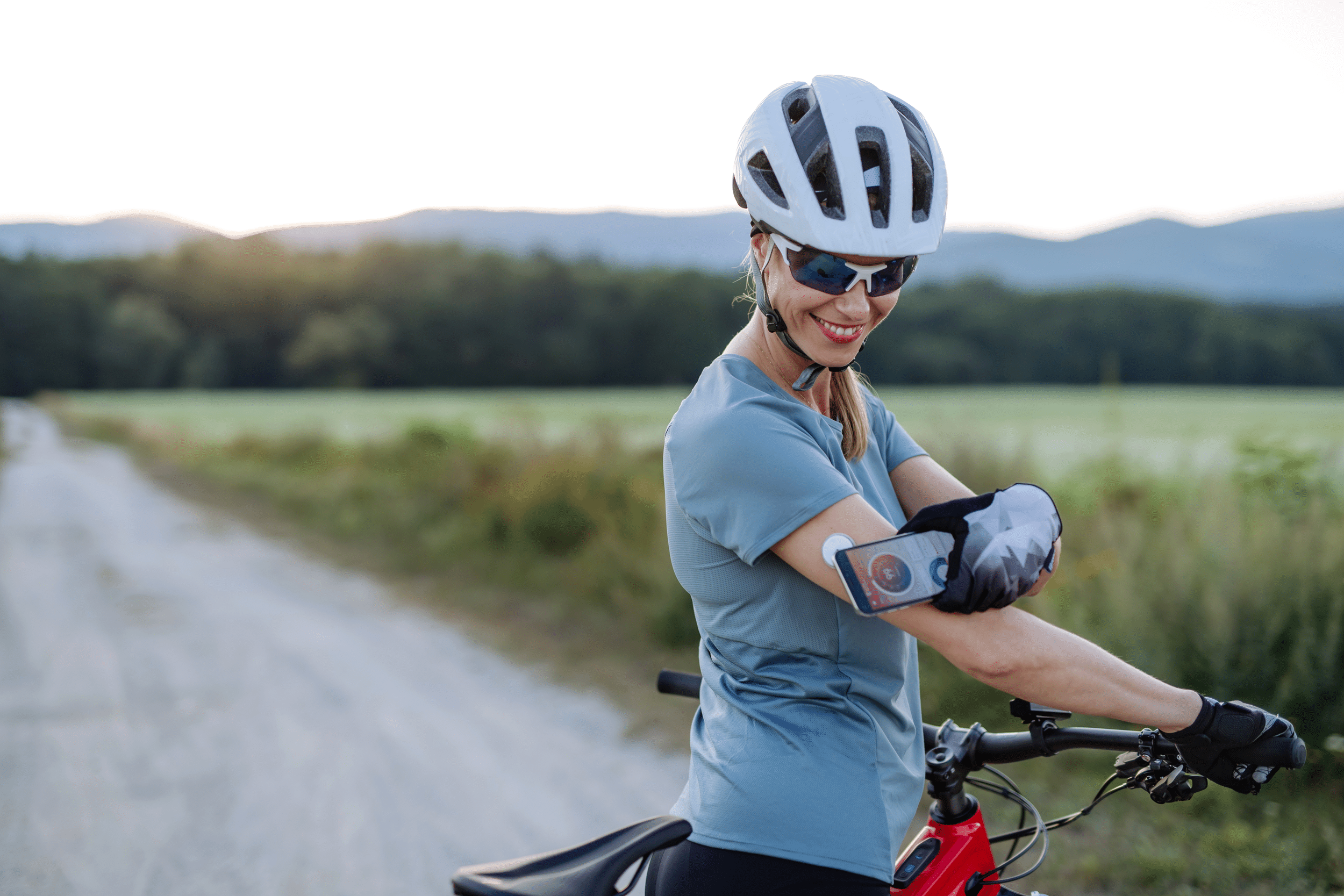 diabetic cyclist connecting continuous glucose monitor with her smartphone to monitor her blood sugar levels in real time
