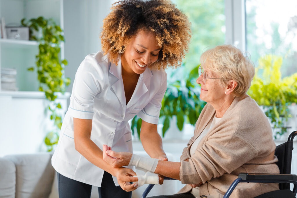 nurse wrapping arm of woman in wheelchair