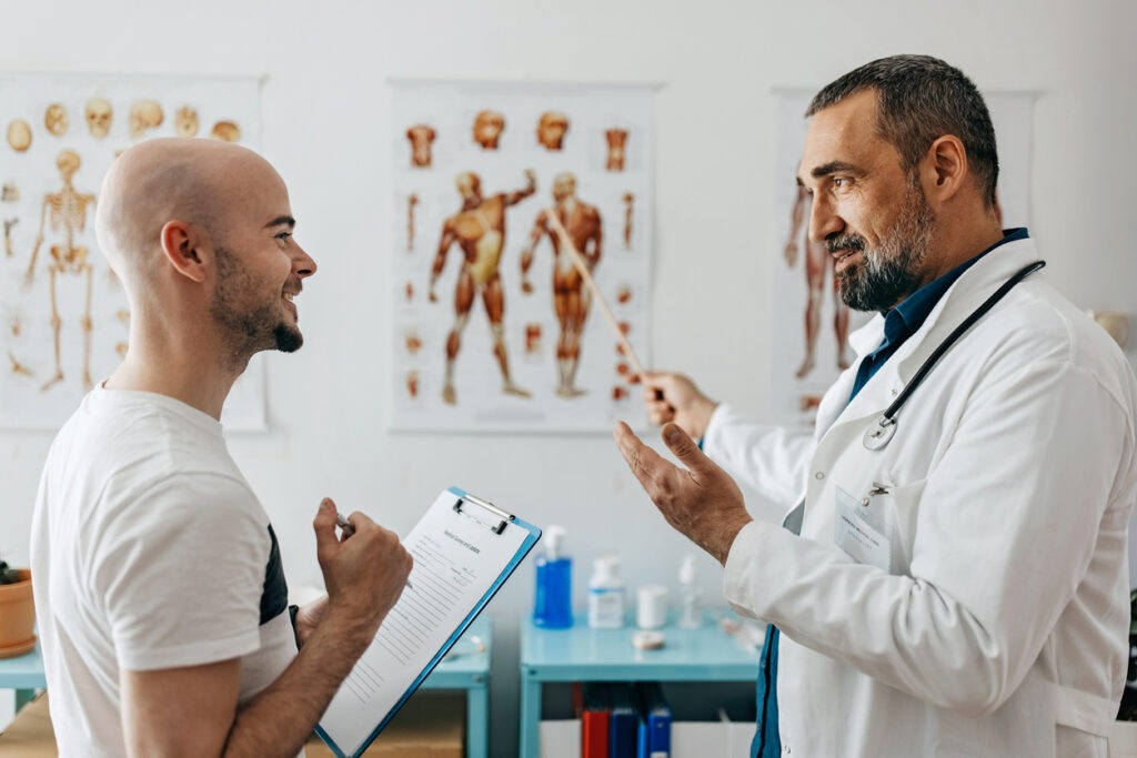 patient taking notes while speaking with doctor